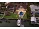 An aerial view of a waterfront estate featuring a pool, lush landscaping, and a private boat dock at 875 Siesta Key Cir, Sarasota, FL 34242