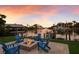 Backyard firepit with blue Adirondack chairs offering waterfront views and dock access at 875 Siesta Key Cir, Sarasota, FL 34242