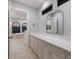 Bathroom featuring a long vanity with double sinks, a large mirror, and access to the tub at 875 Siesta Key Cir, Sarasota, FL 34242