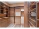 Custom walk-in closet with multiple tiers of shelving, drawers and glass door cabinets at 875 Siesta Key Cir, Sarasota, FL 34242