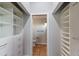 Walk-in closet with custom shelving and drawers, leading to bathroom at 875 Siesta Key Cir, Sarasota, FL 34242