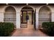 Arched gate and doorway leading to the home's entry, surrounded by manicured landscaping at 875 Siesta Key Cir, Sarasota, FL 34242