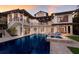 Luxury multi-story home with a large pool, lounge chairs, and outdoor patio at 875 Siesta Key Cir, Sarasota, FL 34242