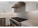 Gourmet kitchen boasts a professional-grade range, pot filler, and custom vent hood at 875 Siesta Key Cir, Sarasota, FL 34242