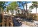 Charming home exterior with a white facade, a wooden fence, and mature trees at 919 N Osprey Ave, Sarasota, FL 34236