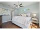 Main bedroom featuring wood floors, a ceiling fan, and a large window for lots of natural light at 10490 Old Grove Cir, Bradenton, FL 34212