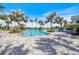 Inviting community pool surrounded by palm trees and comfortable lounge seating for relaxation at 11200 Mcdermott Ct, Englewood, FL 34223