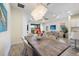 Bright dining room with a rustic table, a modern chandelier, and a view to the living area at 11200 Mcdermott Ct, Englewood, FL 34223