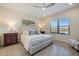 Cozy main bedroom featuring a lake view, ceiling fan, and matching night stands at 11200 Mcdermott Ct, Englewood, FL 34223
