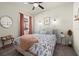 Cozy bedroom featuring a floral patterned bedspread, soft lighting, and neutral-toned walls at 11569 11Th E Ave, Bradenton, FL 34212