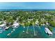 Aerial view of a charming waterfront community with lush greenery and clear turquoise waters in the distance at 12204 45Th Avenue W Dr, Cortez, FL 34215