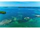 Expansive aerial showcasing open water and the coast; features a boat house with dock and various boats at 12204 45Th Avenue W Dr, Cortez, FL 34215