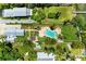 Overhead aerial view displays the kidney-shaped pool and patio area, beautifully landscaped grounds, and two houses at 12204 45Th Avenue W Dr, Cortez, FL 34215