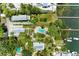 Aerial view of a private backyard with a freeform pool, lush landscaping, and docks along the waterfront at 12204 45Th Avenue W Dr, Cortez, FL 34215