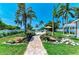 Lush backyard featuring a brick path leading to the pool area, framed by palm trees and manicured landscaping at 12204 45Th Avenue W Dr, Cortez, FL 34215
