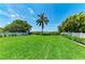Expansive grassy backyard with a white picket fence, providing ample space for outdoor activities and relaxation at 12204 45Th Avenue W Dr, Cortez, FL 34215