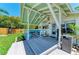 Inviting covered porch with comfortable seating, ceiling fan, and a glimpse of the well-maintained backyard at 12204 45Th Avenue W Dr, Cortez, FL 34215