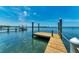 Waterfront dock with wooden pillars, presenting a serene view of the calm water and the expansive sky at 12204 45Th Avenue W Dr, Cortez, FL 34215