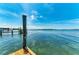 Wooden dock pillar overlooking the serene blue sea, offering a captivating view of the tranquil waterscape at 12204 45Th Avenue W Dr, Cortez, FL 34215