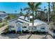 Charming waterfront home with vibrant blue door, lush landscaping, and glimpses of the ocean at 12204 45Th Avenue W Dr, Cortez, FL 34215