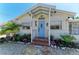 Inviting home entrance with blue door, brick steps, stone pathway, and well-manicured landscaping at 12204 45Th Avenue W Dr, Cortez, FL 34215