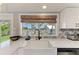 Modern kitchen featuring a farmhouse sink, decorative backsplash, and a view to the backyard at 12204 45Th Avenue W Dr, Cortez, FL 34215