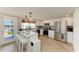 Bright kitchen with white cabinets, herringbone floors, a breakfast bar with seating, and stainless steel appliances at 12204 45Th Avenue W Dr, Cortez, FL 34215
