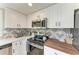 Contemporary kitchen featuring white cabinets, quartz countertops, stainless steel appliances, and stylish backsplash at 12204 45Th Avenue W Dr, Cortez, FL 34215