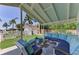 Covered outdoor seating area with comfortable blue cushions, perfect for entertaining or relaxing by the pool at 12204 45Th Avenue W Dr, Cortez, FL 34215