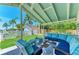Covered outdoor seating area with comfortable blue cushions, perfect for entertaining or relaxing by the pool at 12204 45Th Avenue W Dr, Cortez, FL 34215