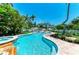 Inviting pool area surrounded by lush landscaping and a white picket fence, perfect for relaxation and privacy at 12204 45Th Avenue W Dr, Cortez, FL 34215