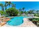 Serene pool featuring a waterfall, spa, and lush landscaping, creating a tranquil oasis at 12204 45Th Avenue W Dr, Cortez, FL 34215