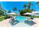 Stunning pool with clear blue water, complete with seating, umbrellas, and tropical landscaping at 12204 45Th Avenue W Dr, Cortez, FL 34215