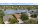 Scenic aerial view showcases the property with a pool overlooking a serene lake and lush green surroundings at 12211 Aster Ave, Bradenton, FL 34212