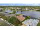 Stunning aerial shot of a home backing onto a tranquil lake, complete with a screened-in pool and manicured backyard at 12211 Aster Ave, Bradenton, FL 34212