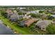 An aerial view shows homes with screened in pools, lush lawns, and landscaping near a peaceful lake at 12211 Aster Ave, Bradenton, FL 34212