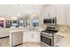 Well-lit kitchen with stainless steel appliances, granite countertops, and a view to the backyard at 12211 Aster Ave, Bradenton, FL 34212