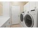 Modern laundry room featuring white cabinets, countertop space, and front-load washer and dryer at 12211 Aster Ave, Bradenton, FL 34212