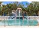 Fun splashpad with colorful play structures set in a sparkling pool, surrounded by lush tropical vegetation at 12211 Aster Ave, Bradenton, FL 34212