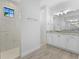 This bathroom features a double sink vanity with granite countertop and a large walk-in shower at 12396 Bacchus Rd, Port Charlotte, FL 33981