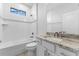 This bathroom features a shower and bathtub combination with a granite-topped vanity at 12396 Bacchus Rd, Port Charlotte, FL 33981