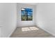 This bedroom features wood-look tile flooring, a window, and white walls at 12396 Bacchus Rd, Port Charlotte, FL 33981