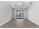 This bedroom features wood-look tile flooring, ceiling fan, and sliding doors with access to the pool at 12396 Bacchus Rd, Port Charlotte, FL 33981