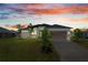 Contemporary home boasts a two-car garage, a well-manicured lawn, and lush tropical landscaping at 12396 Bacchus Rd, Port Charlotte, FL 33981