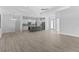 Open floor plan featuring wood-look tile, modern lighting, and a gray kitchen island at 12396 Bacchus Rd, Port Charlotte, FL 33981