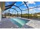Inviting pool area enclosed with a screen showcasing a sparkling pool, patio, and serene waterfront views at 12396 Bacchus Rd, Port Charlotte, FL 33981