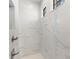 This walk-in shower features white tile, a window, and a pebble accent tile at 12396 Bacchus Rd, Port Charlotte, FL 33981