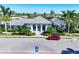Elegant home showcasing manicured landscaping, a red car, and a symmetrical design at 12717 Deep Blue Pl, Bradenton, FL 34211