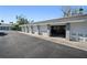 Row of garages with light grey paint, white doors, black driveway, and tropical landscaping at 1323 Perico Point Cir # 107, Bradenton, FL 34209