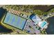 Aerial view of the community tennis courts, pool, and clubhouse near the waterway at 1323 Perico Point Cir # 107, Bradenton, FL 34209